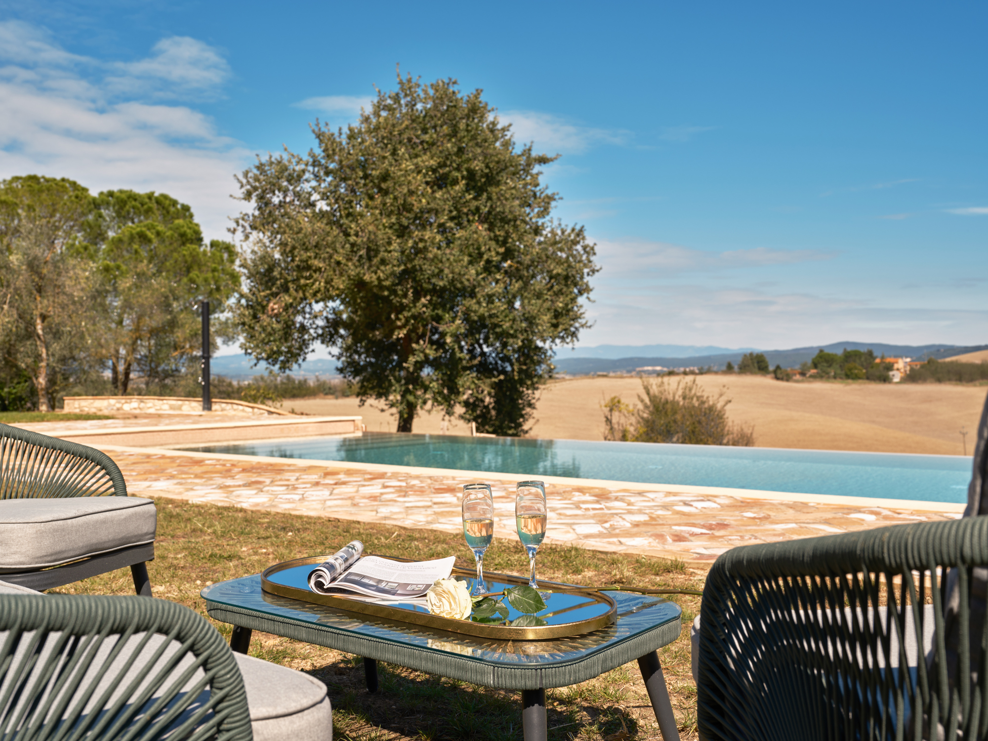 Interior of Villa Eos: a stone arch frames a sitting area with a soft grey sofa and warm ochre walls.